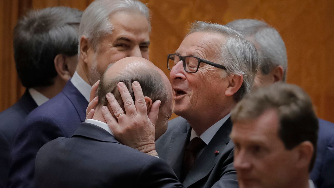 Jean-Claude Juncker, the president of the European Commission, kisses former Romanian President Traian Basescu before a session of parliament in Bucharest, Romania, on Thursday, May 11. The anniversary session marked 10 years since Romania joined the European Union.
