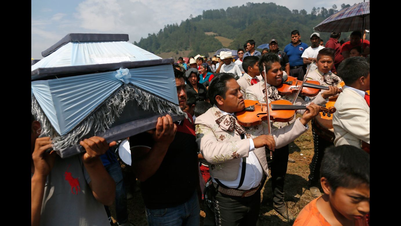 A Mariachi group plays violins during a funeral procession in the Mexican village of San Isidro on Wednesday, May 10. An explosion at a fireworks store killed 14 people.