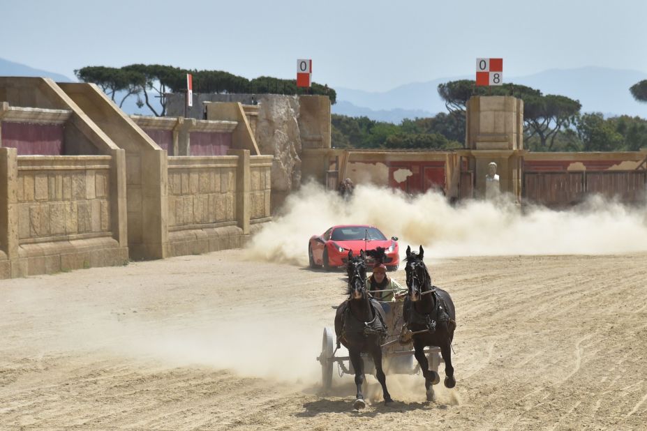 Ferrari driver Fabio Barone chases down a horse-drawn chariot in Castel Romano, Italy.