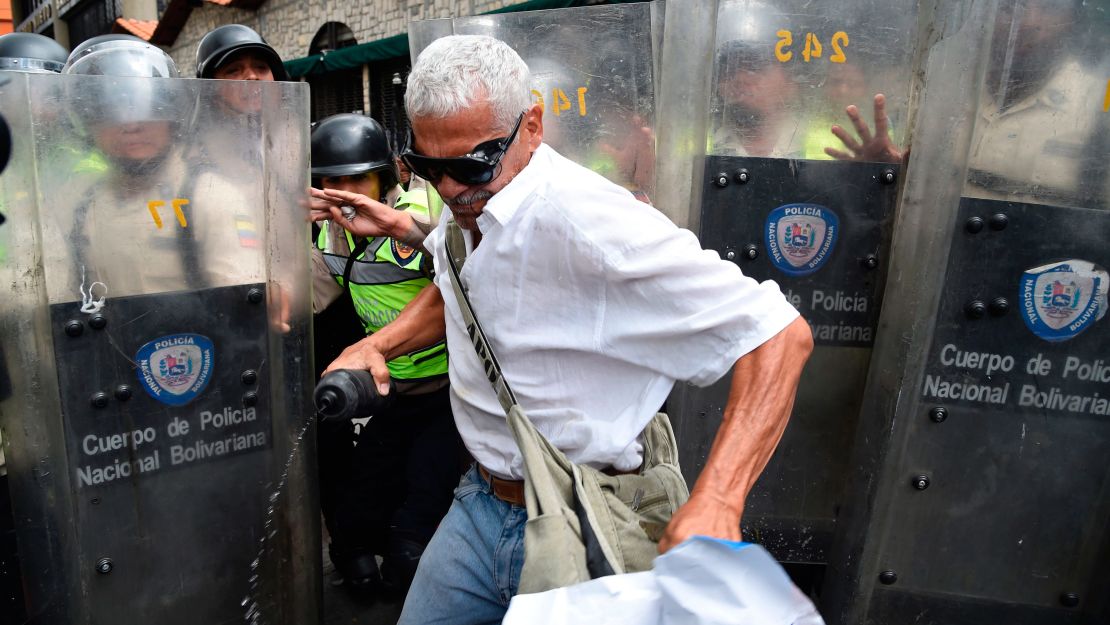 A protester turns away from a line of police officers blocking the path of marchers on Friday. 