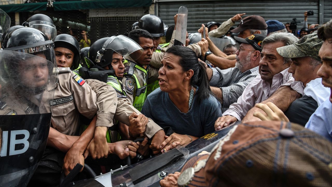 Opposition activists scuffle with riot police in Caracas on May 12.