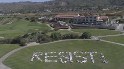 This Saturday, May 13, 2017, photo released by an organization known as Indivisible San Pedro shows protesters spelling out the word "RESIST!" at a public park nestled within Trump National Golf Course in Rancho Palos Verdes, Calif. The flash mob-style protest calls for a special prosecutor to investigate collusion by the Trump campaign with Russia's interference with the 2016 elections. (Indivisible San Pedro via AP )