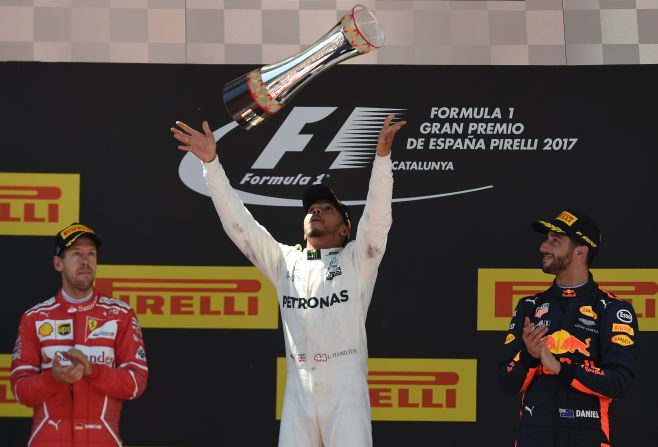 Hamilton celebrates on the podium flanked by second-placed Vettel and Red Bull's Daniel Ricciardo who finished third. 
