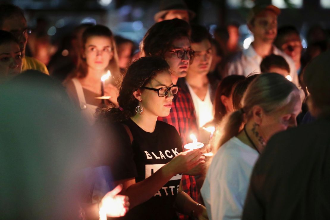 People who support removal of the monuments hold candles during a counterprotest on Sunday.