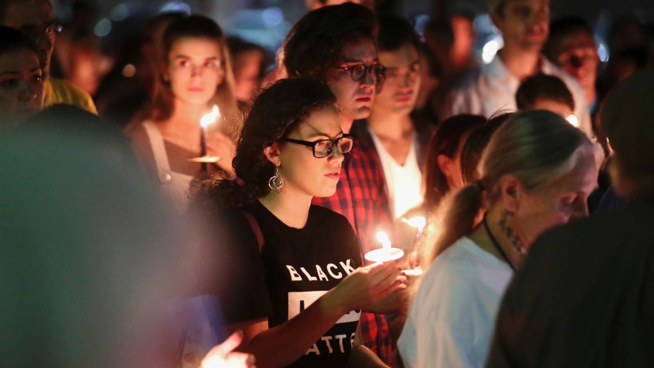 People who support removal of the monuments hold candles during a counterprotest on Sunday.