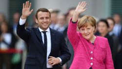 New French President Emmanuel Macron, left, and  German Chancellor Angela Merkel wave to journalists at the chancellery  in Berlin Monday, May 15, 2017, during the first foreign trip of Macron after his inauguration the day before.  (Bernd von Jutrczenka/dpa via AP)
