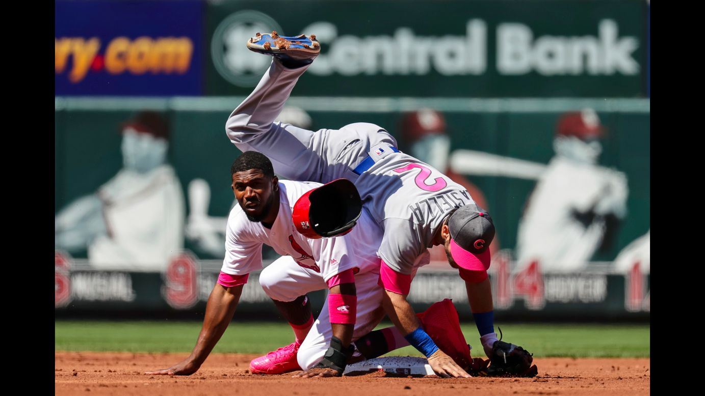 Tommy La Stella, an infielder for the Chicago Cubs, falls over St. Louis' Dexter Fowler after turning a double play on Saturday, May 13. Major League Baseball teams were wearing pink for Mother's Day.
