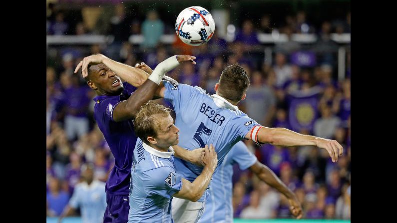 Orlando City's Cyle Larin, left, competes for a header with Sporting Kansas City's Seth Sinovic, center, and Matt Besler during a Major League Soccer match on Saturday, May 13.