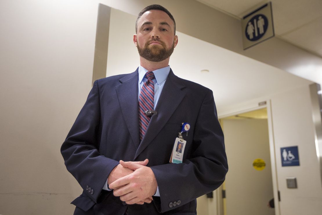 Ryan Curran of Massachusetts General Hospital in front of the bathrooms in the main lobby.