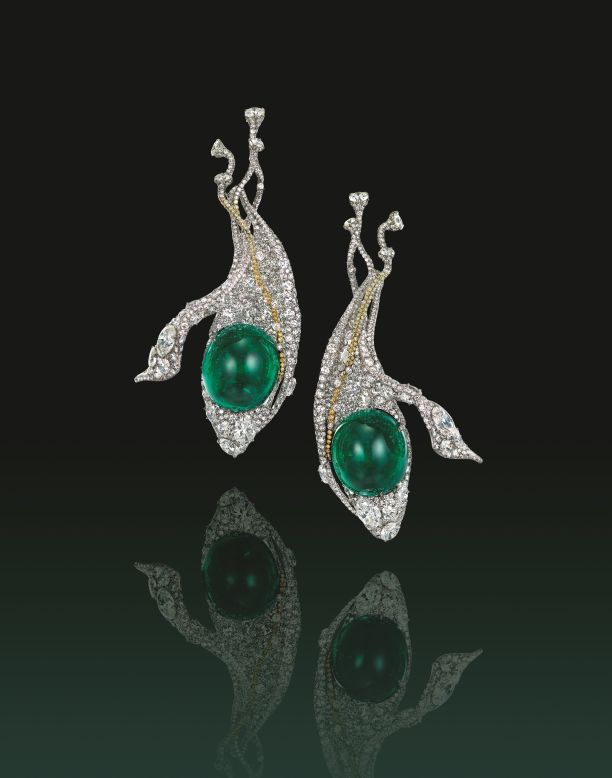 This set of ear accessories by Cindy Chao is crafted in titanium around a pair of rare 29.49 carat and 26.81 carat cabochon emeralds, further "suspended" from a yellow diamond string.