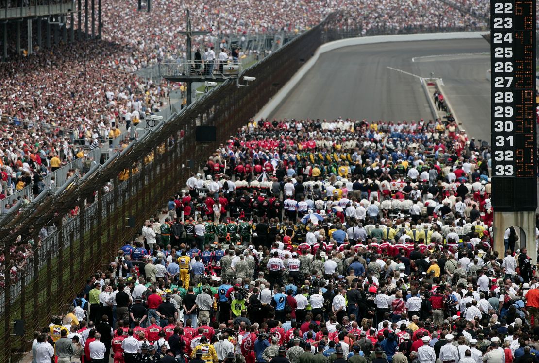 The field of drivers and their teams stand for the national anthem before the Indianapolis 500 in 2008. 