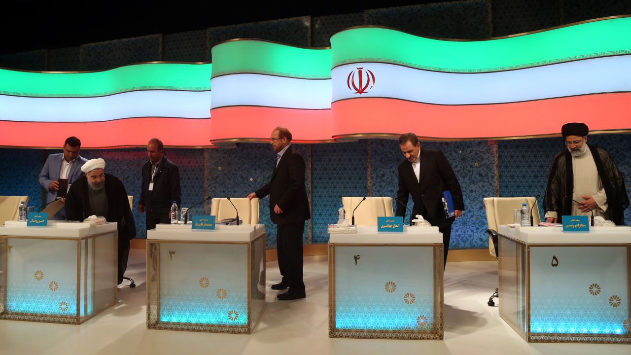 Rouhani (L) and Raisi (R) take their seats for a televised debate in late April.