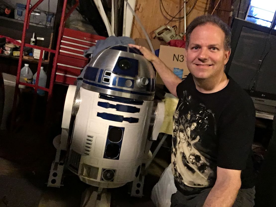 William Magalio poses with the life-sized R2-D2 droid he's building at his house.