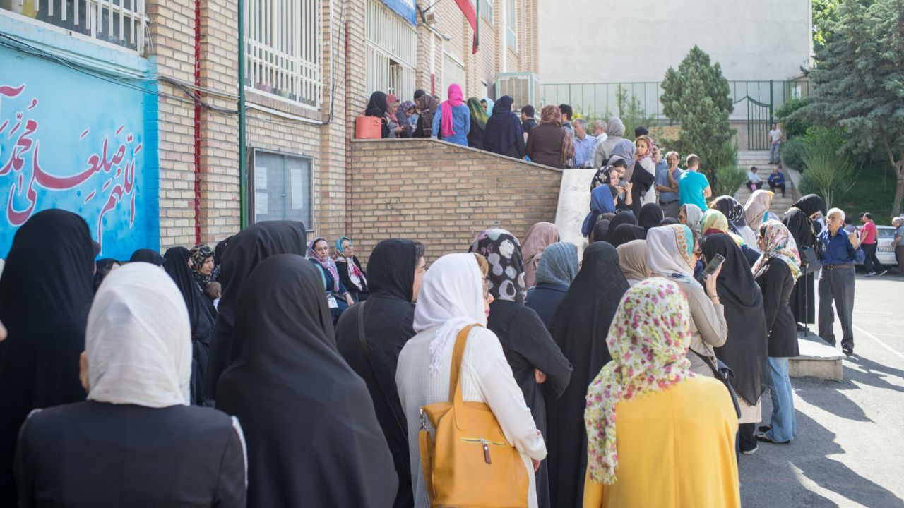 Iranians queue to cast their votes at a polling station in Tehran. 