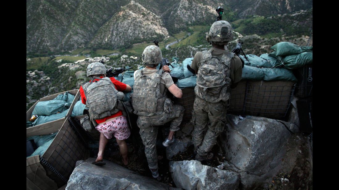 US soldiers take defensive positions after receiving fire from Taliban positions in Afghanistan's Kunar Province on May 11, 2009. Army Spc. Zachary Boyd, left, was wearing "I love NY" boxer shorts after rushing from his sleeping quarters to join his fellow platoon members.