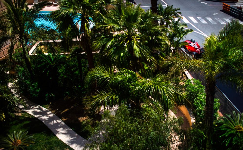 Ferrari's Kimi Raikkonen glimpsed through the palm trees lining the track.