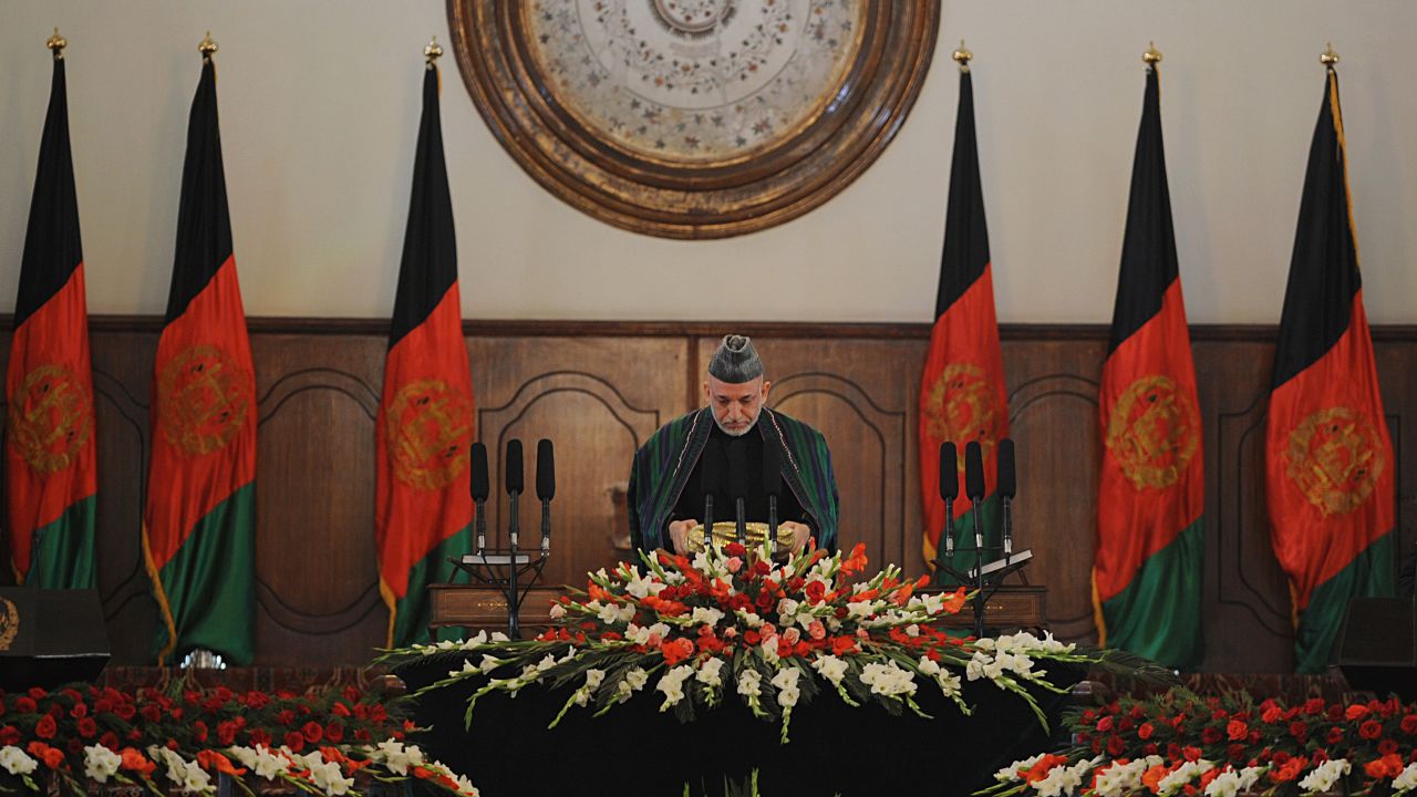 Afghan President Hamid Karzai prepares to kiss a copy of the Quran during his swearing-in ceremony on November 19, 2009. He won a second term after Foreign Minister Abdullah Abdullah dropped out of a runoff.