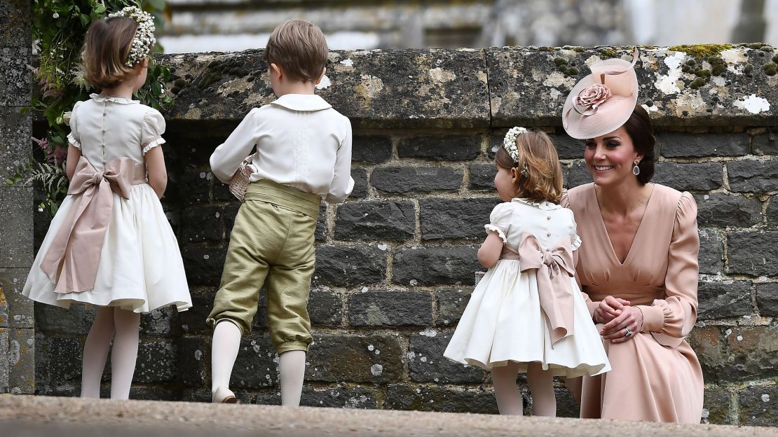 Catherine, Duchess of Cambridge stands with her daughter Britain's princess Charlotte, a flower girl, following the wedding of her sister Pippa Middleton to James Matthews. 