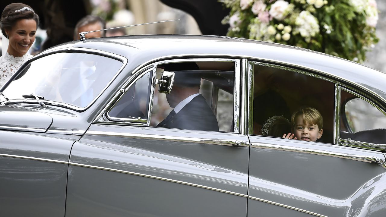 Prince George waves as he leaves in a car after attending his aunt's wedding.