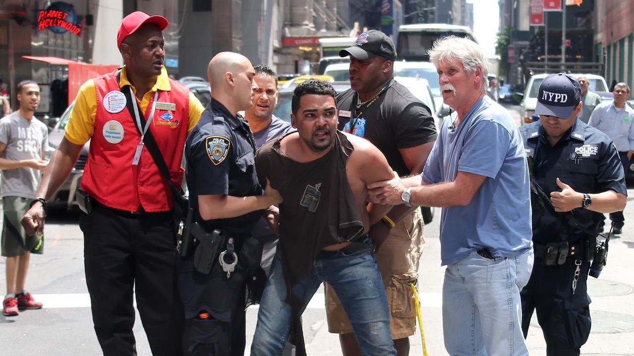 Heroes Alpha Balde and Kenya Bradix are pictured with New York City police officers and other bystanders apprehending Richard Rojas.