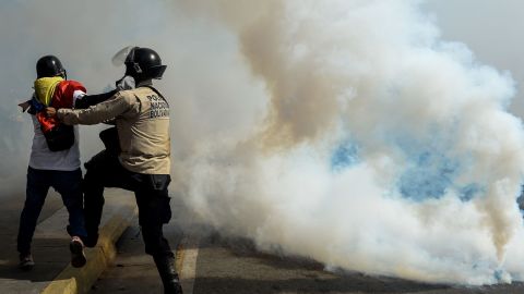 A police officer struggles with a demonstrator May 20 during an anti-government protest in Caracas.