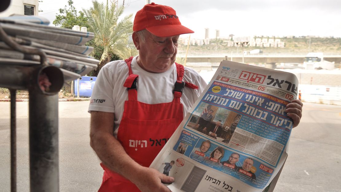 A man sells newspapers at Haifa bus station.