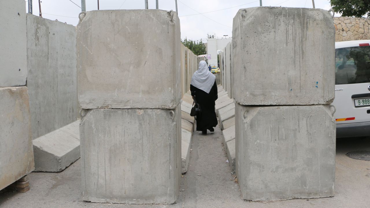 A Palestinian woman crosses through the wall at the Bethlehem checkpoint.