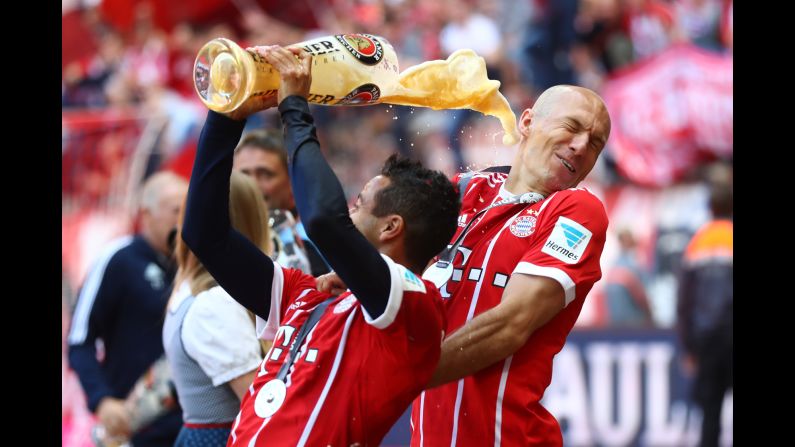 Arjen Robben is showered in beer by Bayern Munich teammate Thiago Alcantara as the German soccer club celebrated its fifth straight league title on Saturday, May 20.
