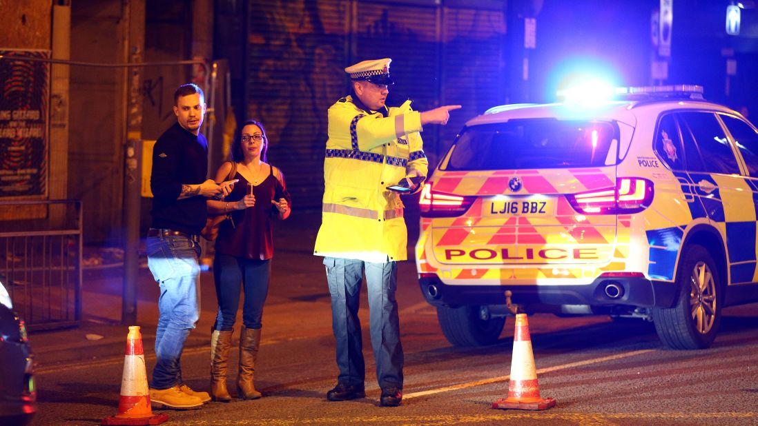 People stand by a cordoned-off street close to the arena.