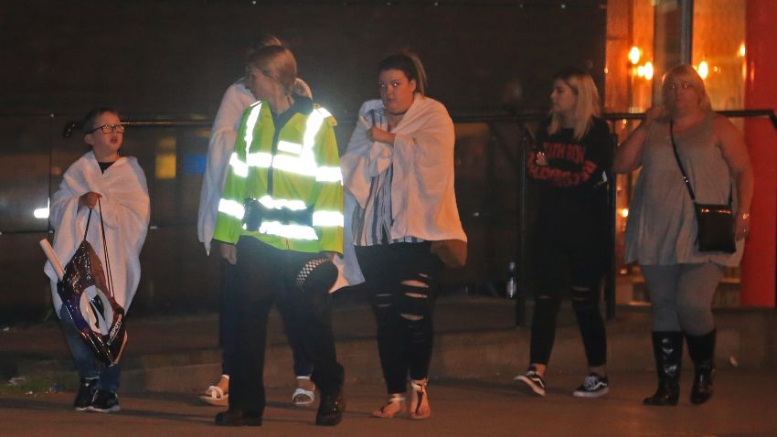 MANCHESTER, UNITED KINGDOM - MAY 23: A British police officer escorts walking casualties away from the Manchester Arena stadium in Manchester, United Kingdom on May 23, 2017.  A large explosion was reported earlier in the evening and British police confirmed that at least 19 killed and many other wounded at American singer Ariana Grande concert at Manchester Arena. Police said earlier the blast at the 21,000-seat arena shortly before 10.35 p.m. (2135GMT) local time was being investigated as a terror attack. (Photo by Lindsey Parnaby/Anadolu Agency/Getty Images)
