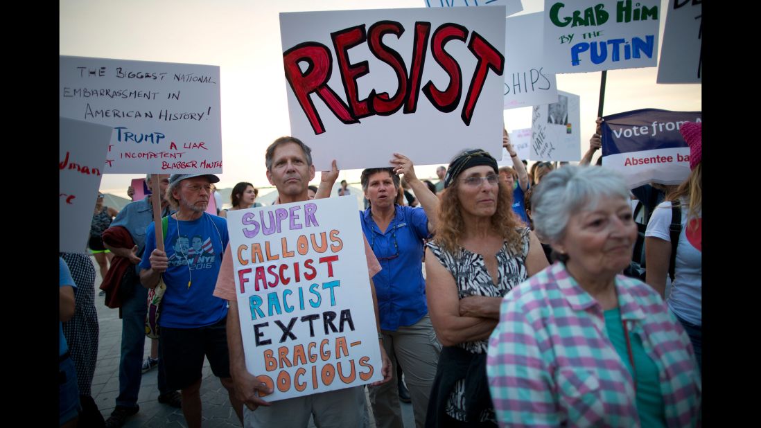 Israeli and American activists hold signs Monday, May 22, during an anti-Trump protest next to the US embassy in Tel Aviv, Israel.