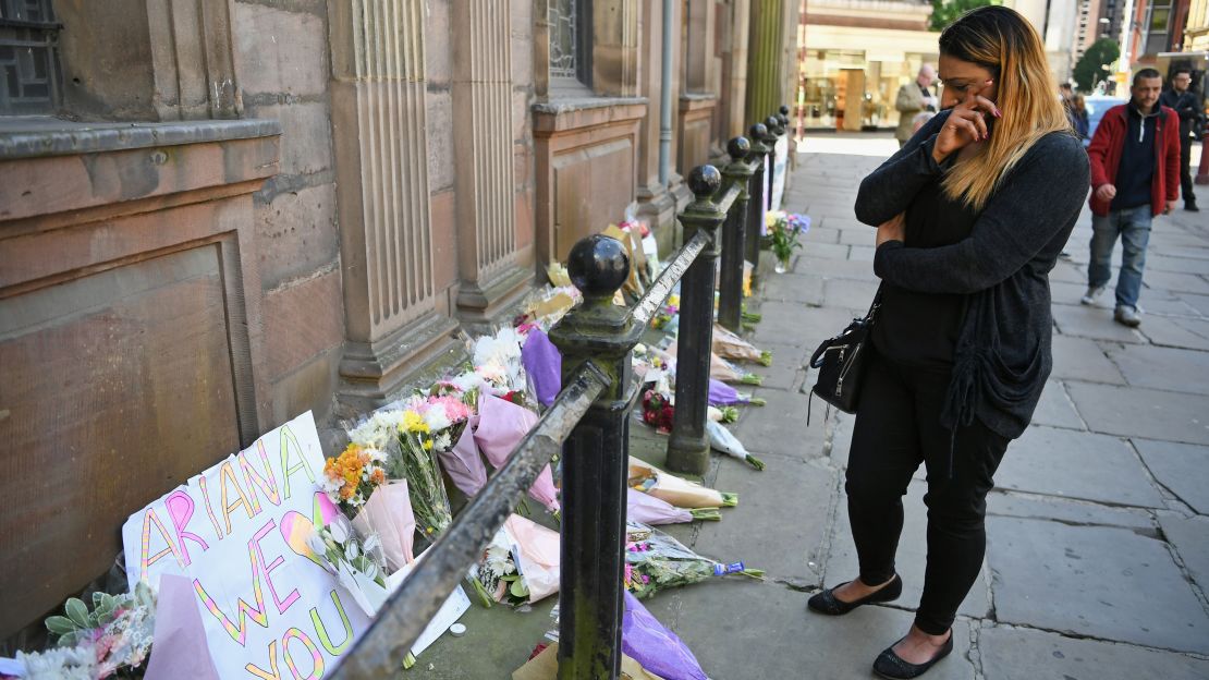 A woman appears  emotional as she looks at flowers left in St. Ann Square on Tuesday, May 23, 2017, in Manchester, England.