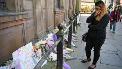 A woman looks emotional as she looks at flowers left in St Ann Square on Tuesday, May 23, 2017 in Manchester,England. At least 22 people were killed in a suicide bombing at a pop concert packed with children in the northern English city of Manchester, in the worst terror incident on British soil since the London bombings of 2005.