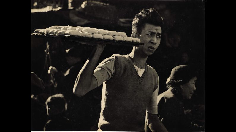  A young man carries a tray of tofu through the Hong Kong's streets