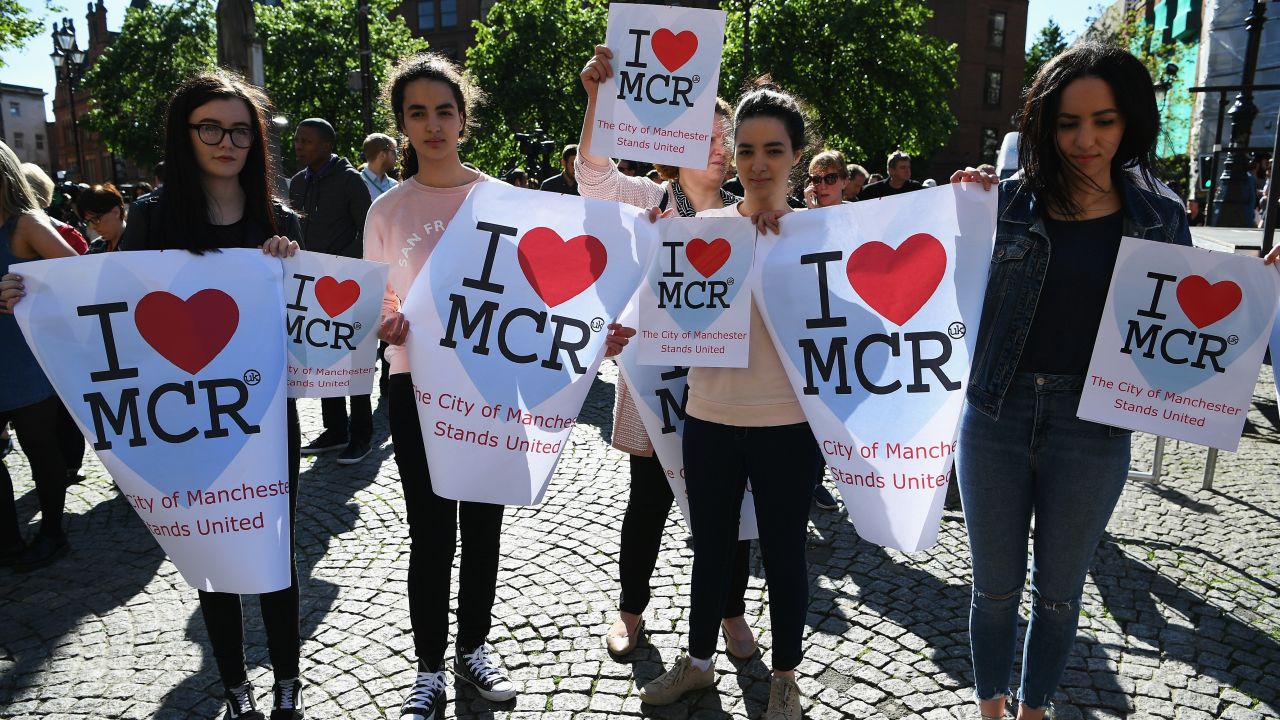 People display signs at the vigil in Manchester's Albert Square.