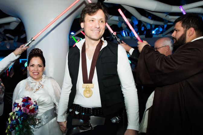 The just-married couple walked through a ceremonial lightsaber arch at their wedding.