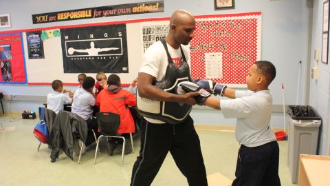 After-school instructor Clemon Clay teaches Justice Watkins boxing moves.