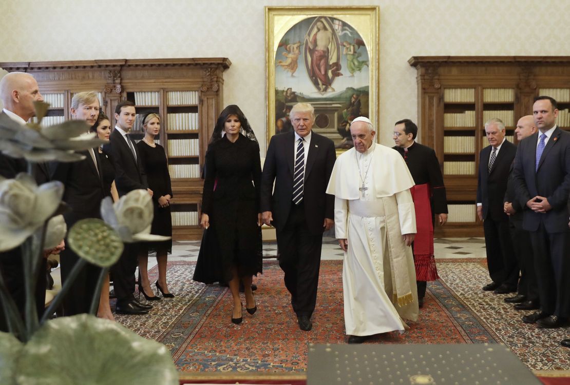 Pope Francis (R) walks along with US President Donald Trump (C) and US First Lady Melania Trump during a private audience at the Vatican on May 24, 2017. 
