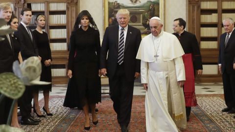 Pope Francis (R) walks along with US President Donald Trump (C) and US First Lady Melania Trump during a private audience at the Vatican on May 24, 2017. 