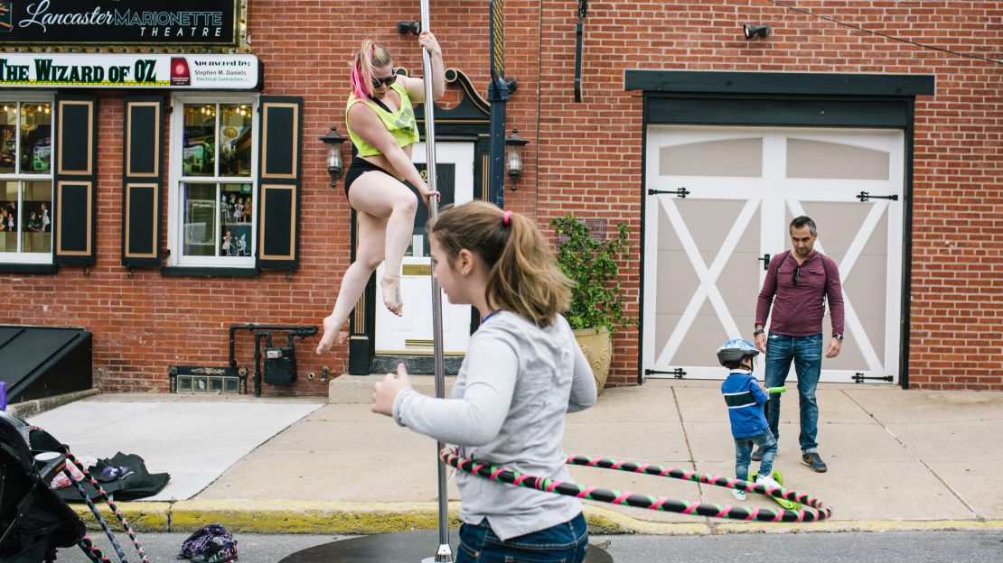 Rachel Syke, 33, does a pole dancing exercise demonstration during Open Streets in Lancaster, Pennsylvania. Open Streets encourages residents to be outside and meet other people in the community.