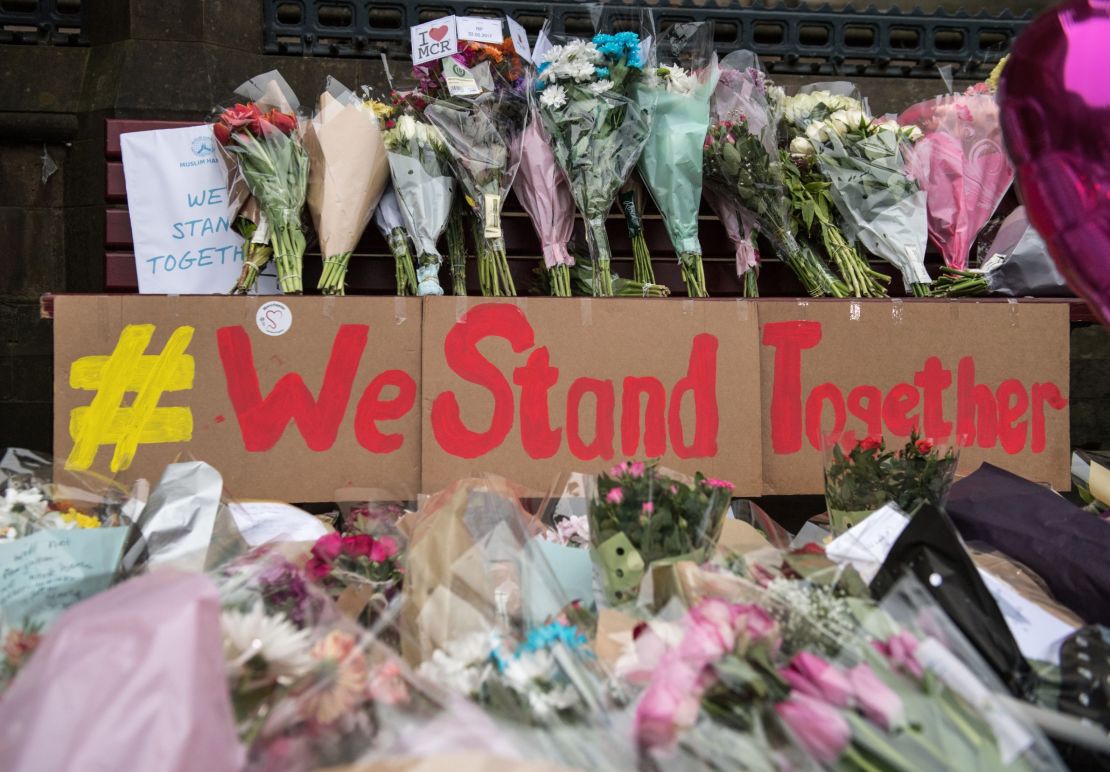 Floral tributes and a message that reads "We Stand Together" are pictured in Albert Square in Manchester two days after the attack.