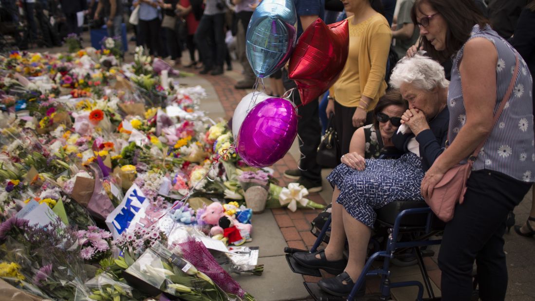 Women cry after placing flowers in Manchester on May 24.