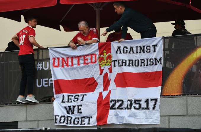 United fans put up a flag in memory of the victims of the Manchester terror attack.