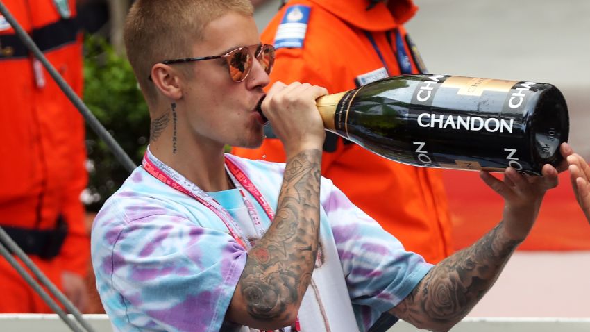 MONTE-CARLO, MONACO - MAY 29: Justin Bieber drinks champagne at the podium during the Monaco Formula One Grand Prix at Circuit de Monaco on May 29, 2016 in Monte-Carlo, Monaco.  (Photo by Lars Baron/Getty Images)