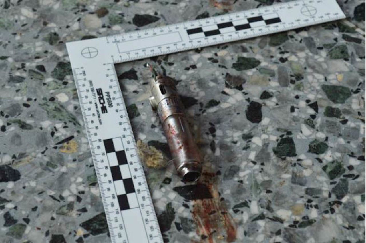 A ruler shows the length of a possible detonator that was reported to have been found in the suspect's left hand.