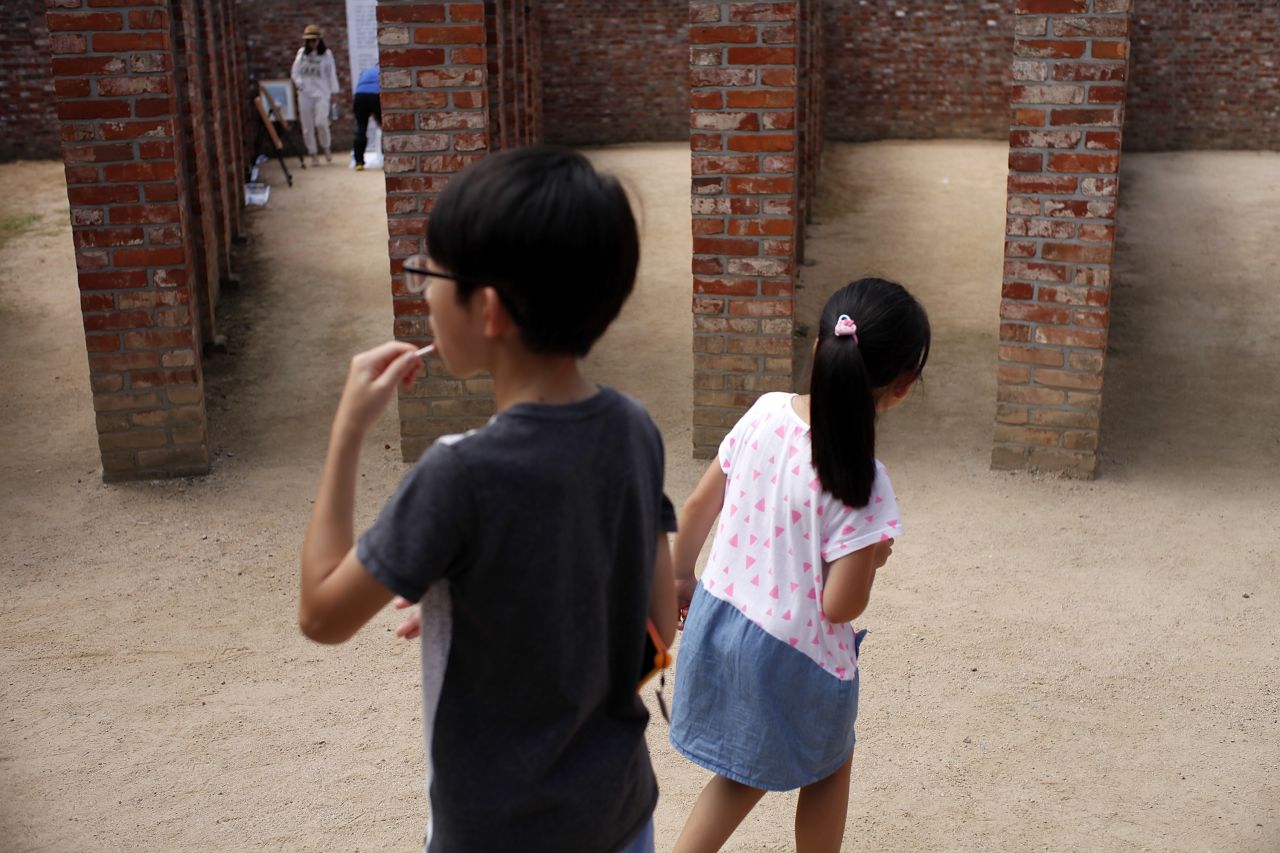 Children look around the sportyard at Seodaemun Prison.