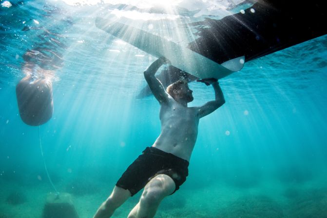 <strong>SoftBank Team Japan:</strong> "During one morning at the Louis Vuitton America's Cup World Series in Toulon I had my water housing with me and followed the shore team at the crack of dawn. This shot is of Simon McLean cleaning the foils prior to racing to eke out every performance gain possible. It was a lucky shot with the morning sun at the right angle and being able to get deep enough while Simon was cleaning" -- Matt Knighton.