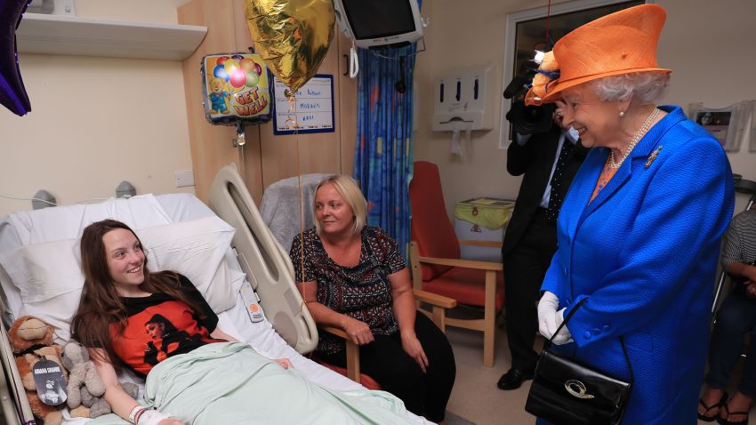 MANCHESTER, ENGLAND - MAY 25:Queen Elizabeth II speaks to Millie Robson, 15, from Co Durham, and her mother, Marie, during a visit to the Royal Manchester Children's Hospital to meet victims of the terror attack on May 25, 2017 in Manchester, England. Queen Elizabeth visited the hospital to meet victims of the Manchester Arena terror attack and to thank members of staff who treated them. (Photo by Peter Byrne/WPA Pool/Getty Images)