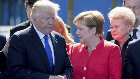Trump stands next to German Chancellor Angela Merkel at the NATO summit.