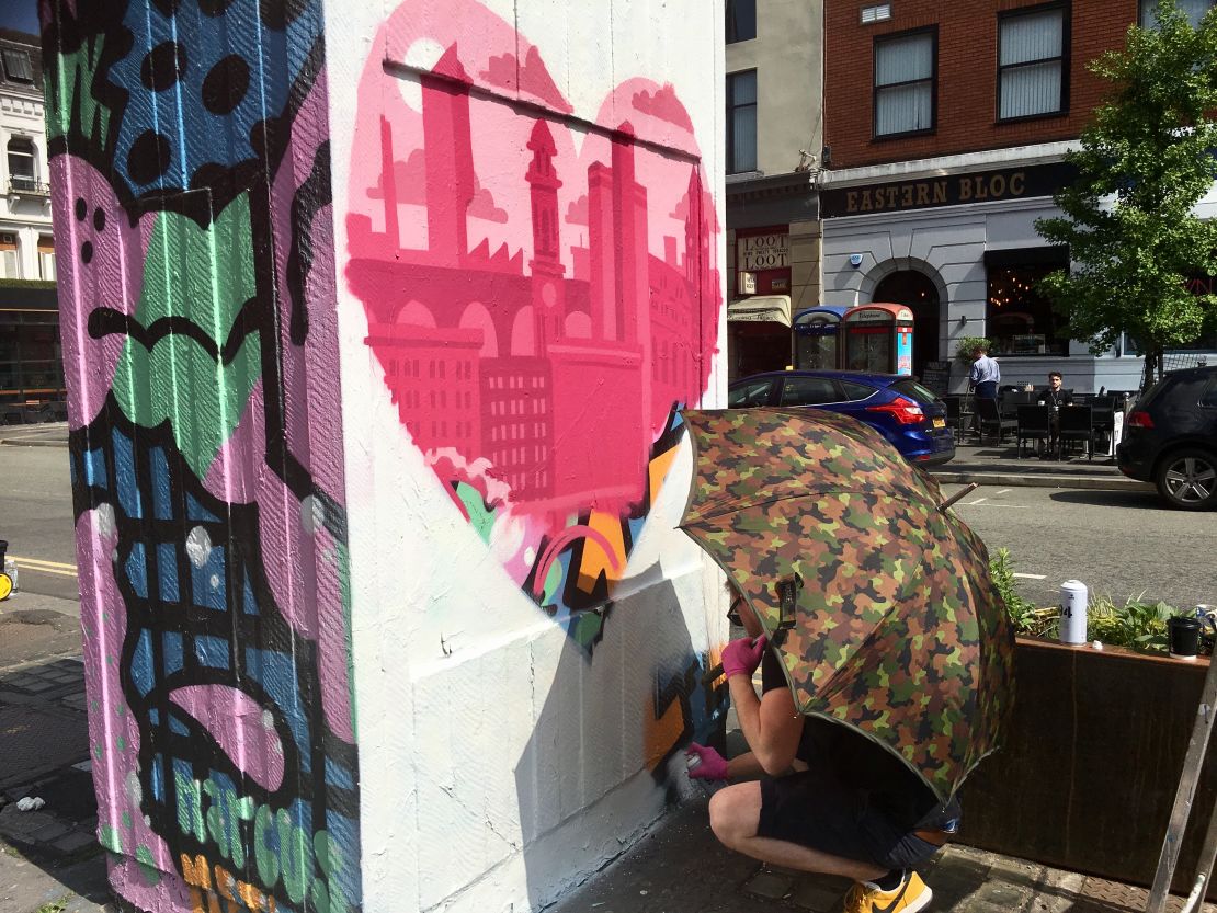 A Manchester street artist works on his tribute in the city's Northern Quarter on Thursday.